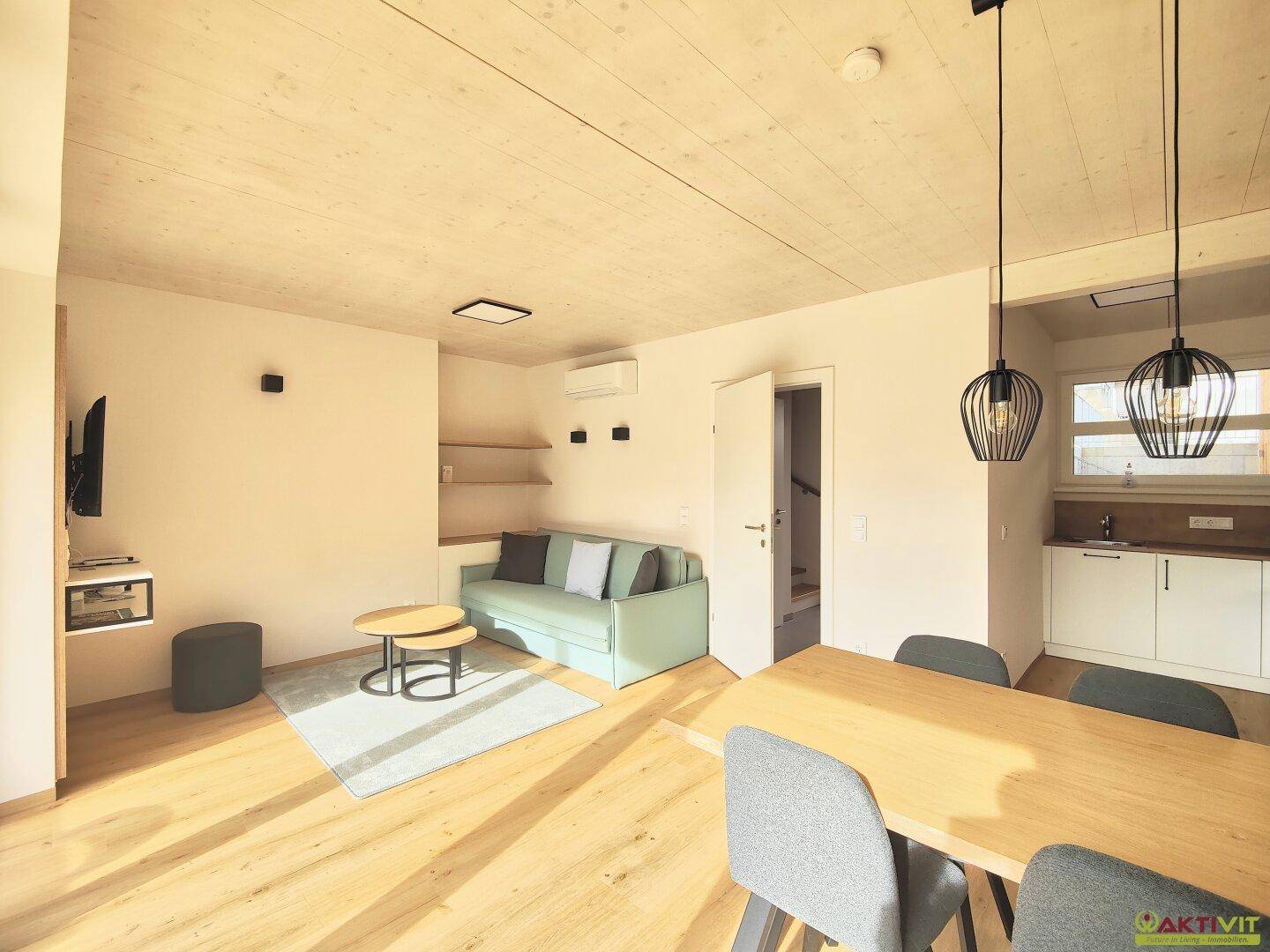 Gemütlicher Wohnbereich mit Sofa, Esstisch und offener Gestaltung, ideal für gesellige Stunden.