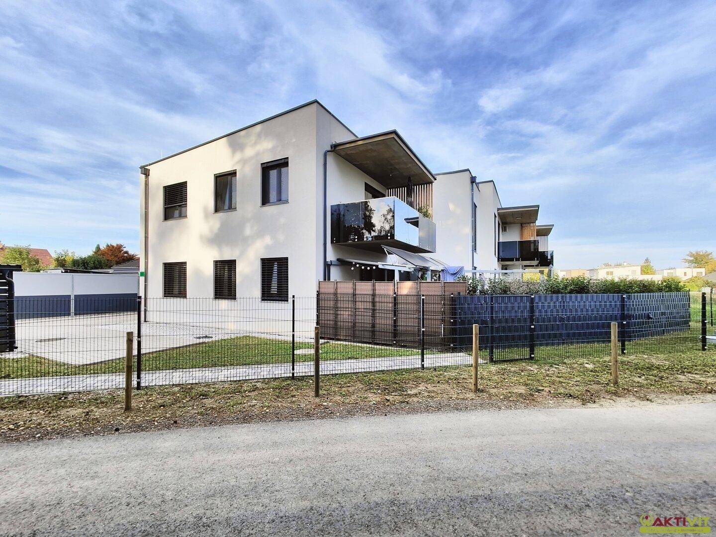 Ansicht der modernen Wohnanlage mit klaren Linien und Balkonen unter blauem Himmel.