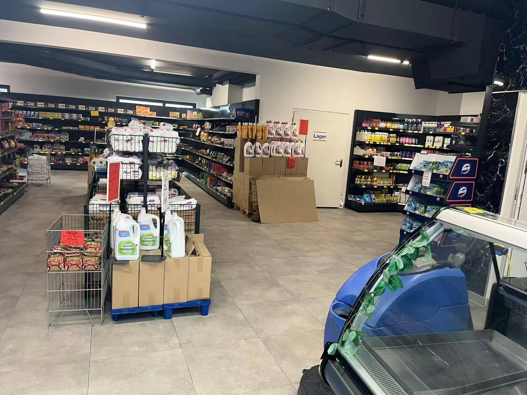 Geräumiger Verkaufsraum mit Regalen voller Produkte, einem Lagerbereich und Fliesenboden.