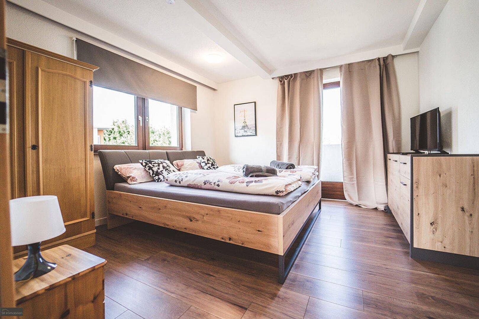 Helles Schlafzimmer mit Holzboden, Doppelbett und Kleiderschrank, ideal für erholsame Nächte.