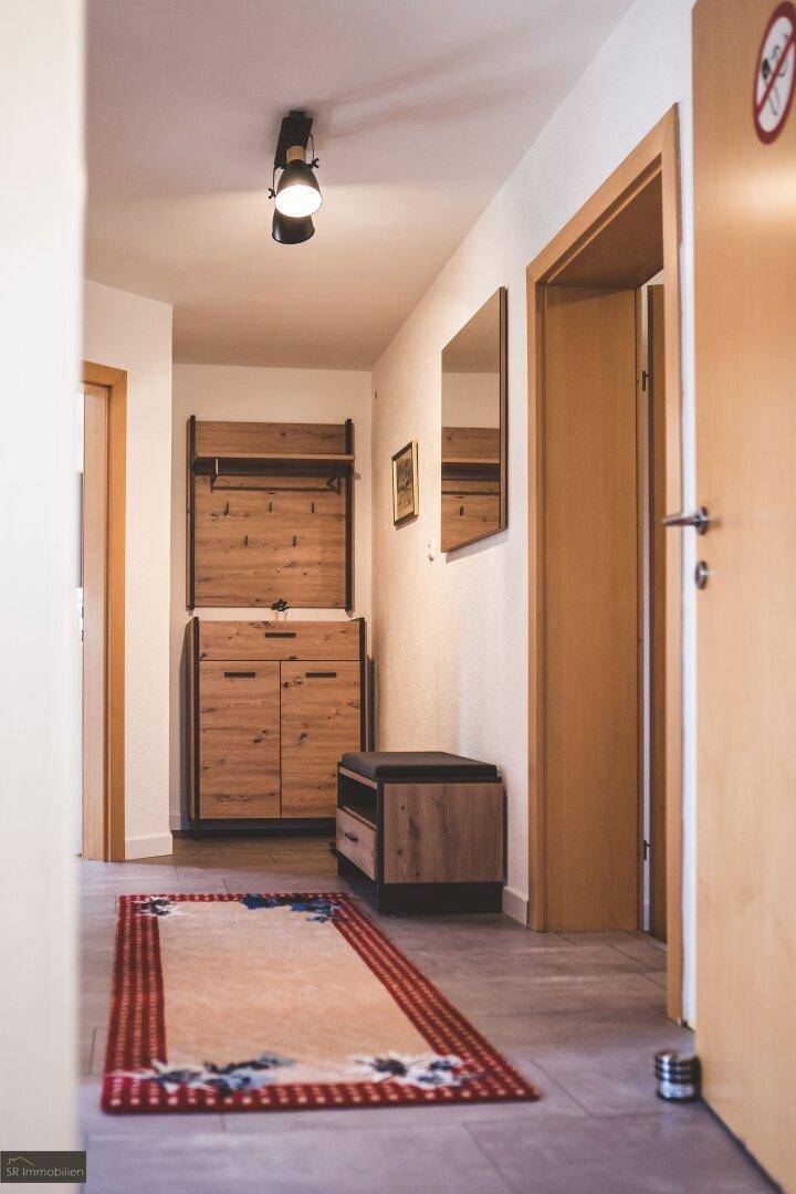 Heller Flur mit Garderobe aus Holz und Spiegel, einladender Eingangsbereich.