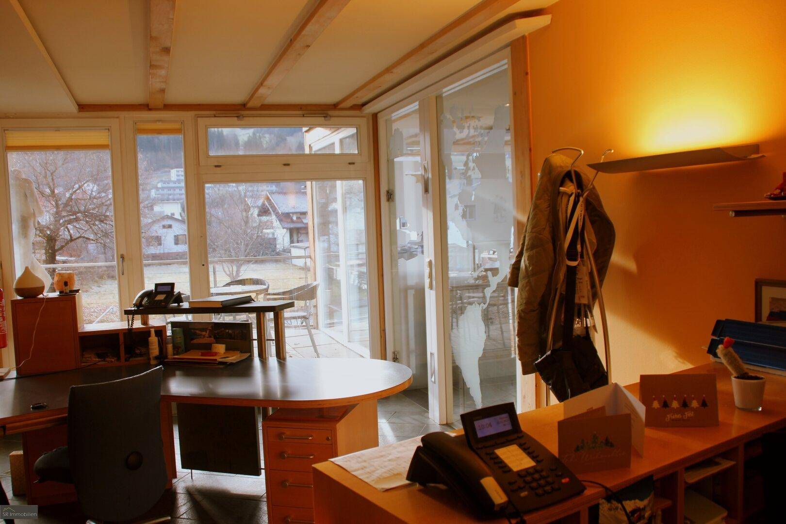 Büro mit Schreibtischen und Zugang zu einem Balkon, bietet einen Blick auf die Umgebung und Natur.