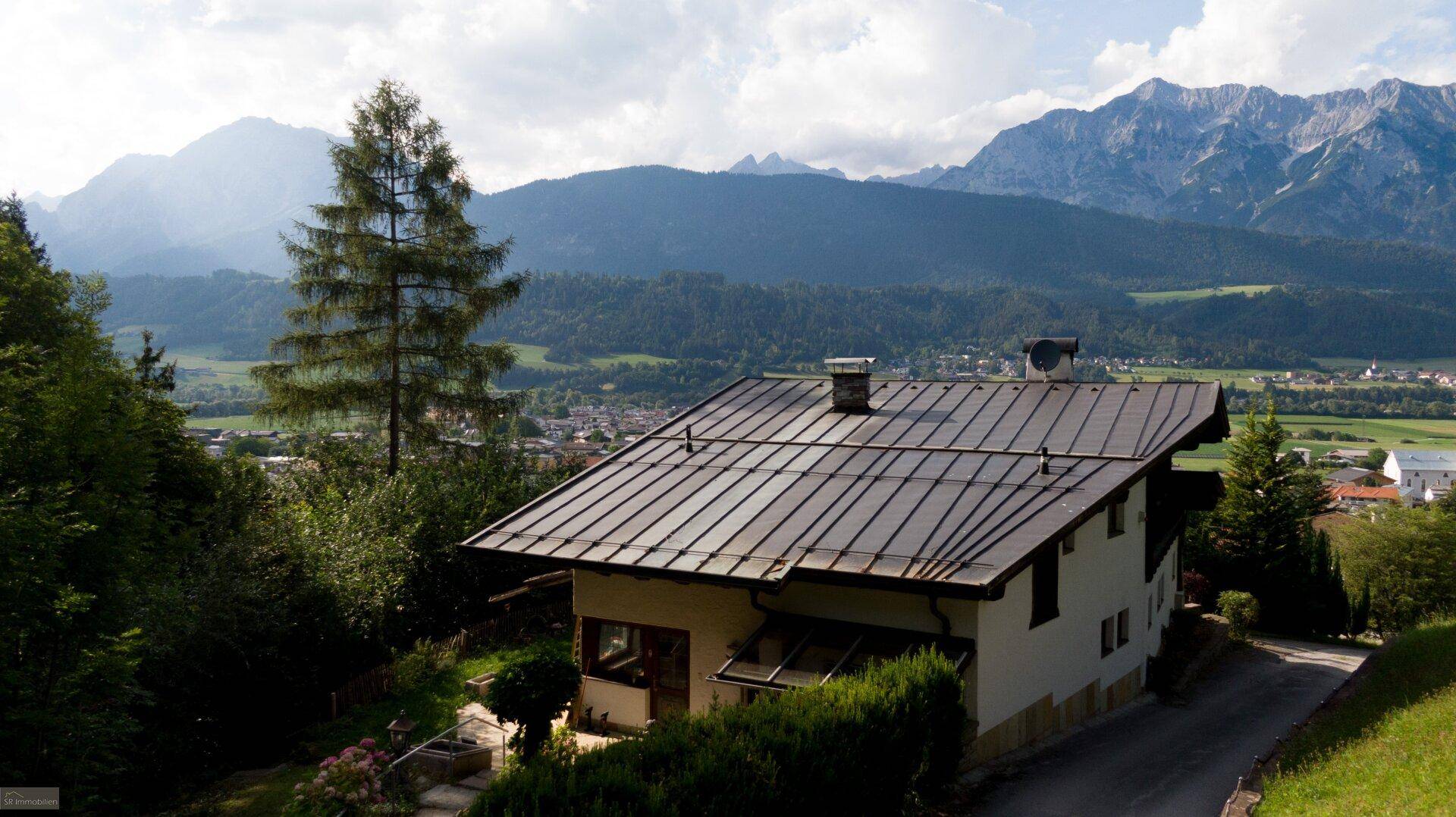 Haus mit Panoramablick auf die majestätischen Berge und ein weites Tal mit einer malerischen Stadt.