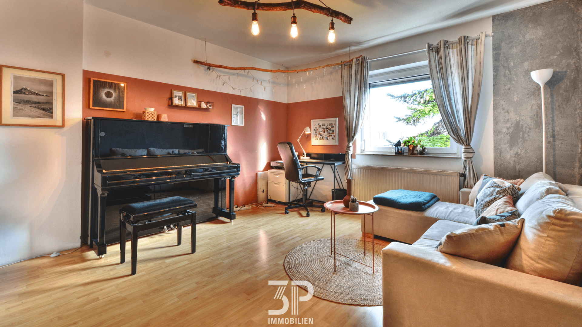 Geräumiges Wohnzimmer mit Klavier, Sofa und Arbeitsbereich am Fenster.