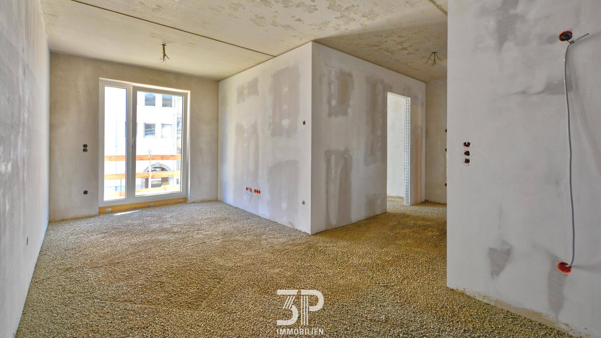 Unfertiger Raum im Rohbau mit großen Fenstern, bereit für den Innenausbau und die Gestaltung.