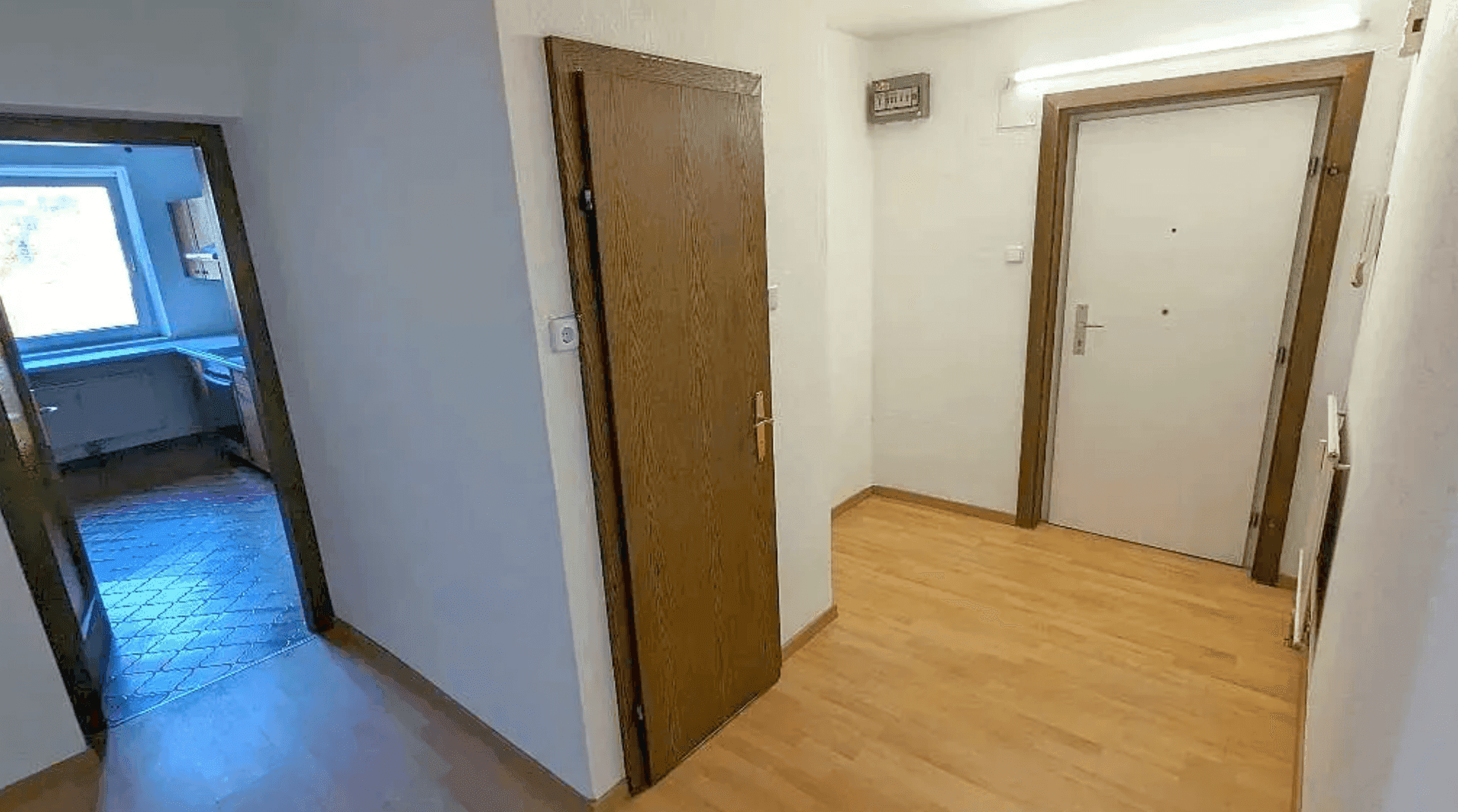 Heller Flur mit Holzboden und mehreren Türen zu angrenzenden Räumen.