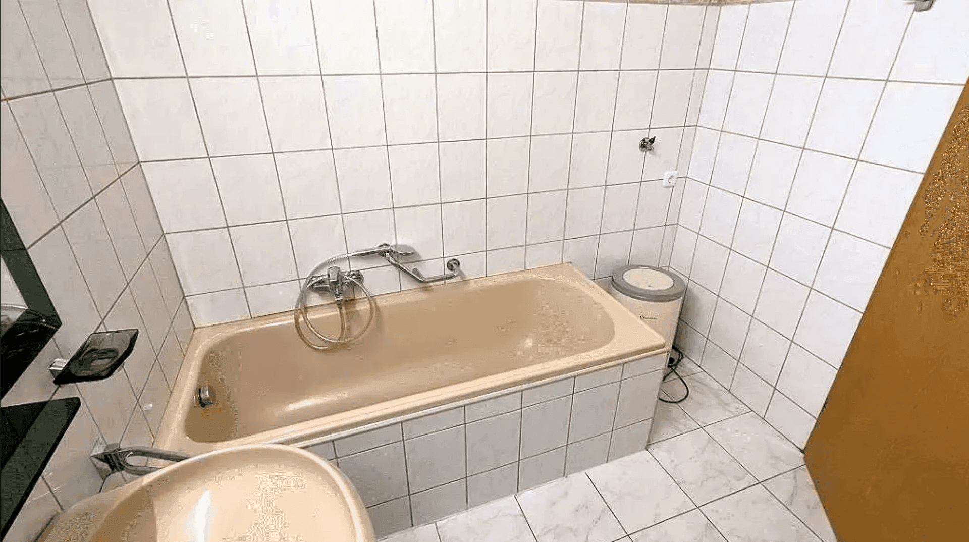 Badezimmer mit Badewanne und Waschbecken, gefliest in einem klassischen Stil.