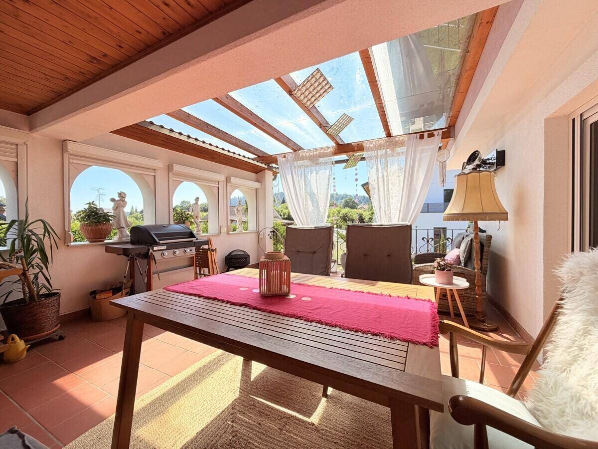 Überdachte Terrasse mit Essbereich, Grill und Blick ins Grüne, ideal für entspannte Stunden.