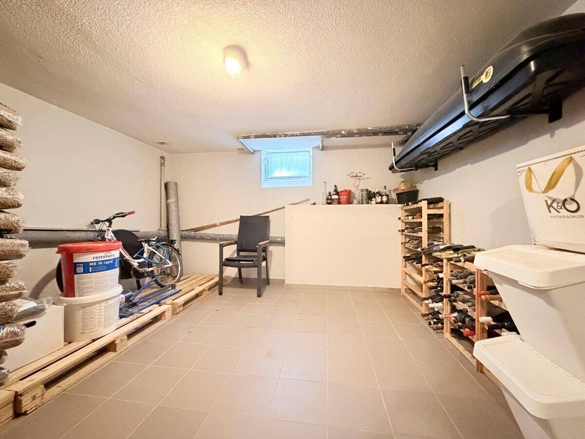 Kellerraum mit Weinregalen, Lagerflächen und einem kleinen Fenster.