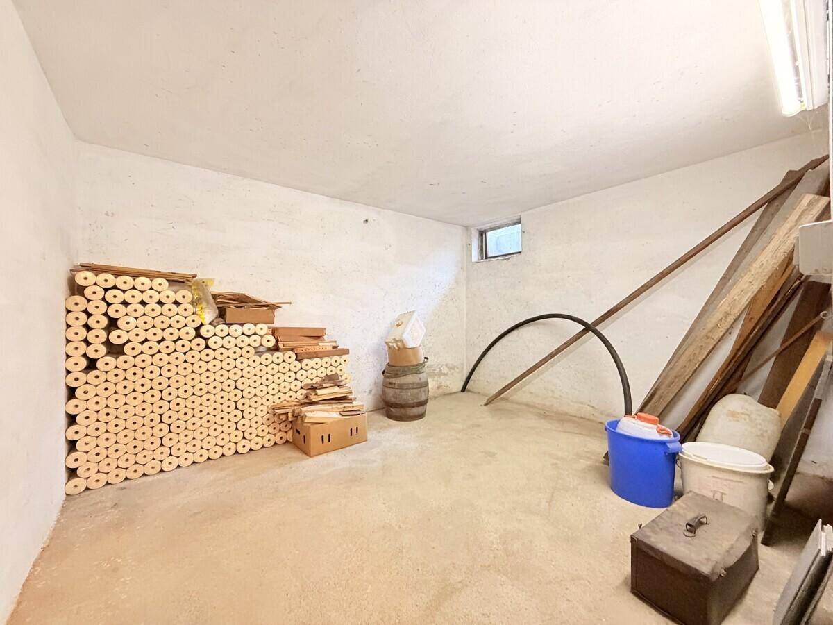 Kellerraum mit Betonboden und kleinem Fenster, ideal zur Lagerung von Gegenständen.