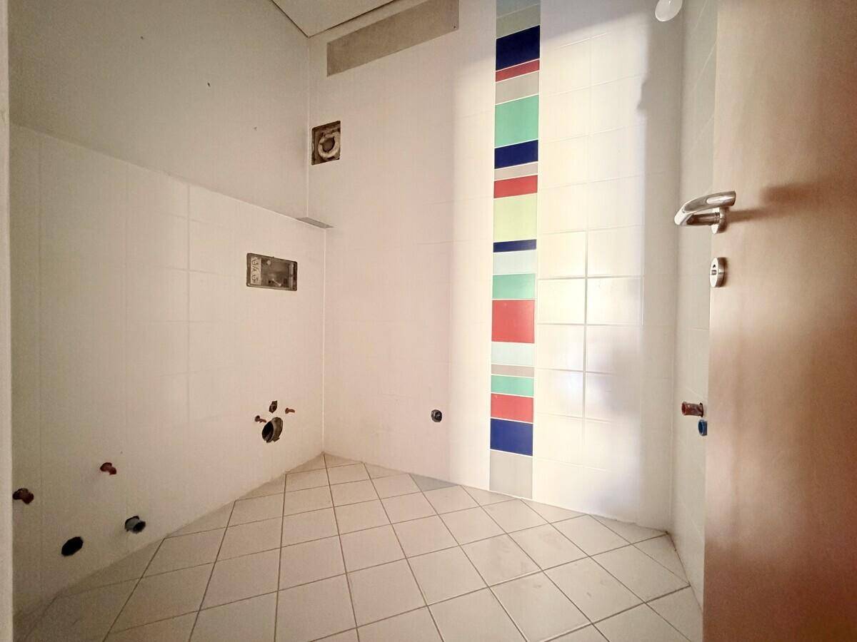 Badezimmer im Rohbau mit weißen Fliesen und farbigen Akzenten, bereit für die Fertigstellung und Installation.
