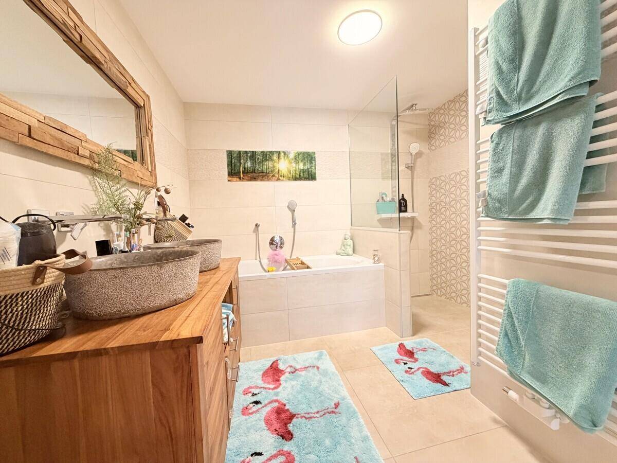 Modernes Badezimmer mit Doppelwaschbecken, Badewanne und begehbarer Dusche.