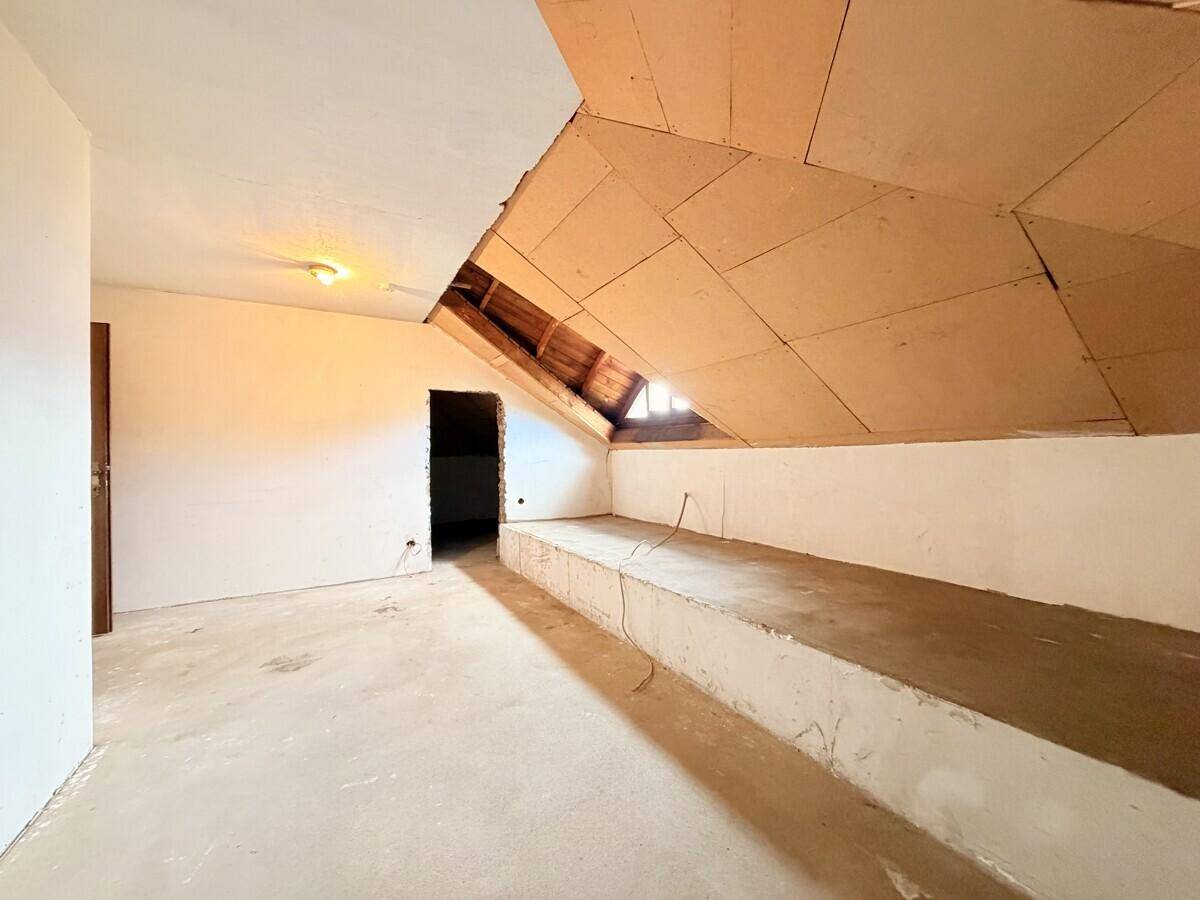 Unausgebautes Dachgeschoss mit schrägen Wänden und sichtbarer Holzkonstruktion, bereit zum Ausbau.