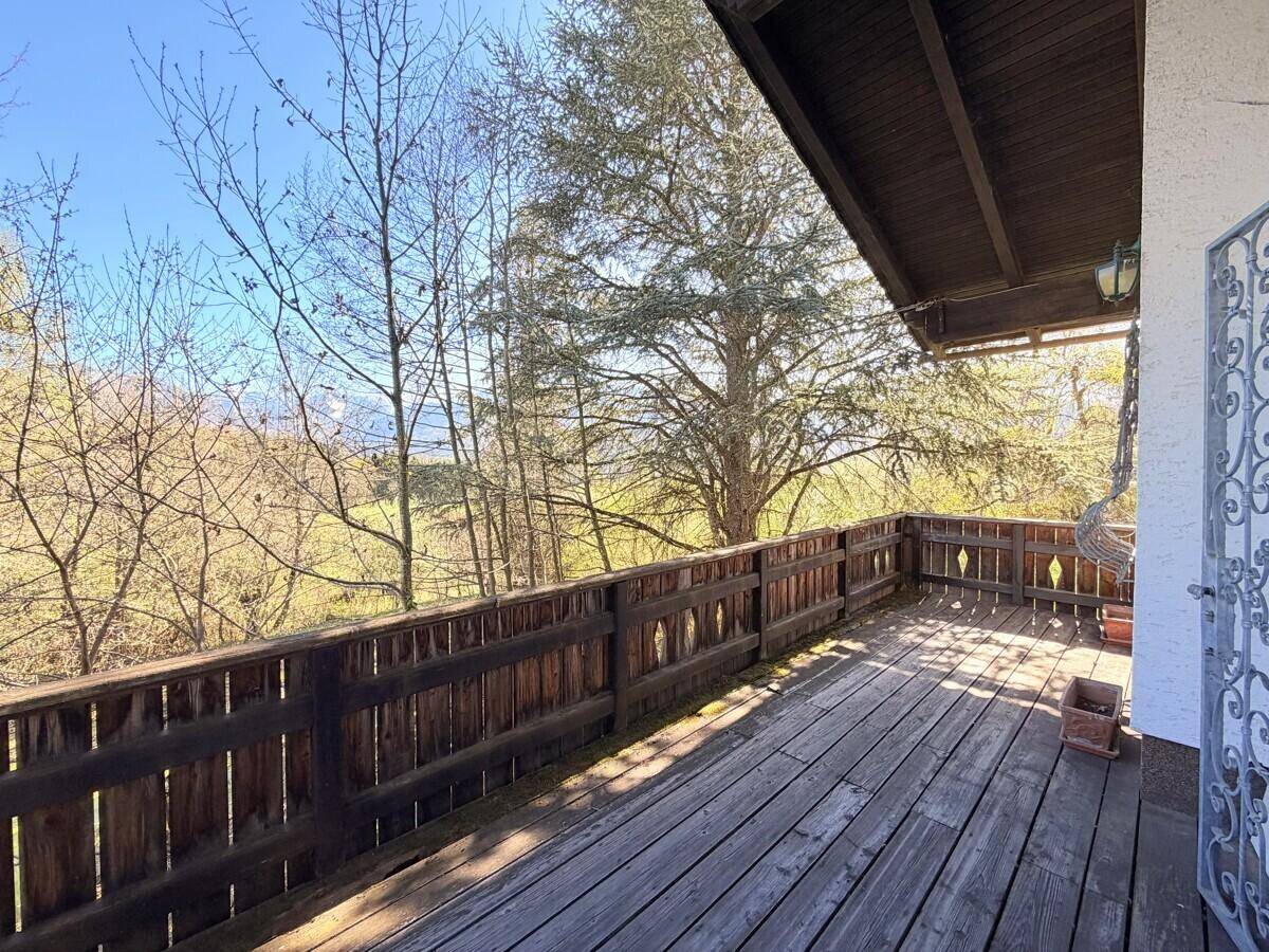 Geräumiger Holzbalkon mit rustikalem Geländer und weitem Blick über die Landschaft.