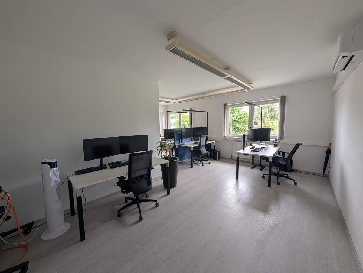 Geräumiges, offenes Büro mit mehreren Arbeitsplätzen, Klimaanlage und viel Tageslicht.
