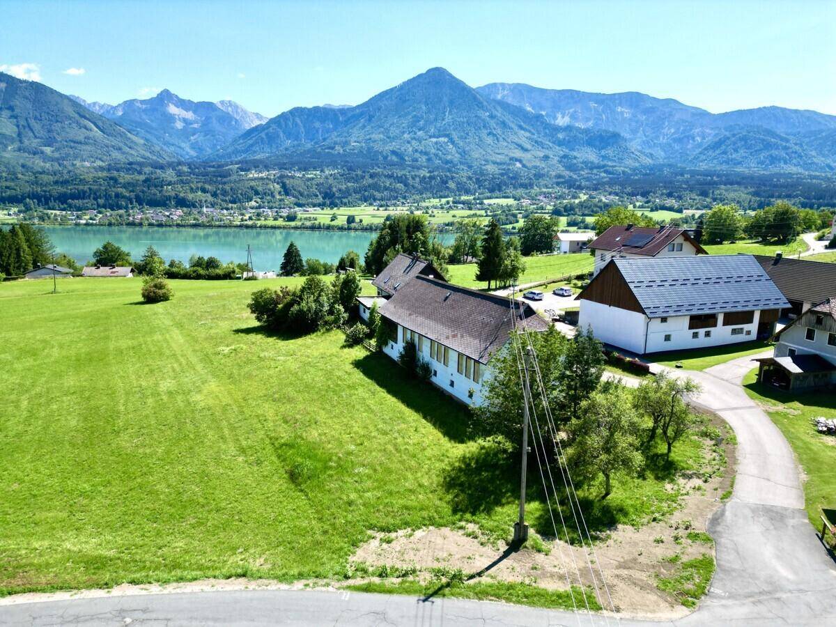 Malerischer Ausblick auf das Anwesen mit See und majestätischen Bergen im Hintergrund.