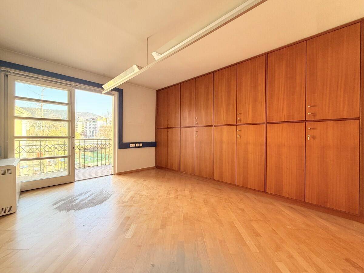 Raum mit Einbauschränken, Holzfußboden und Zugang zu einem kleinen Balkon mit Aussicht.