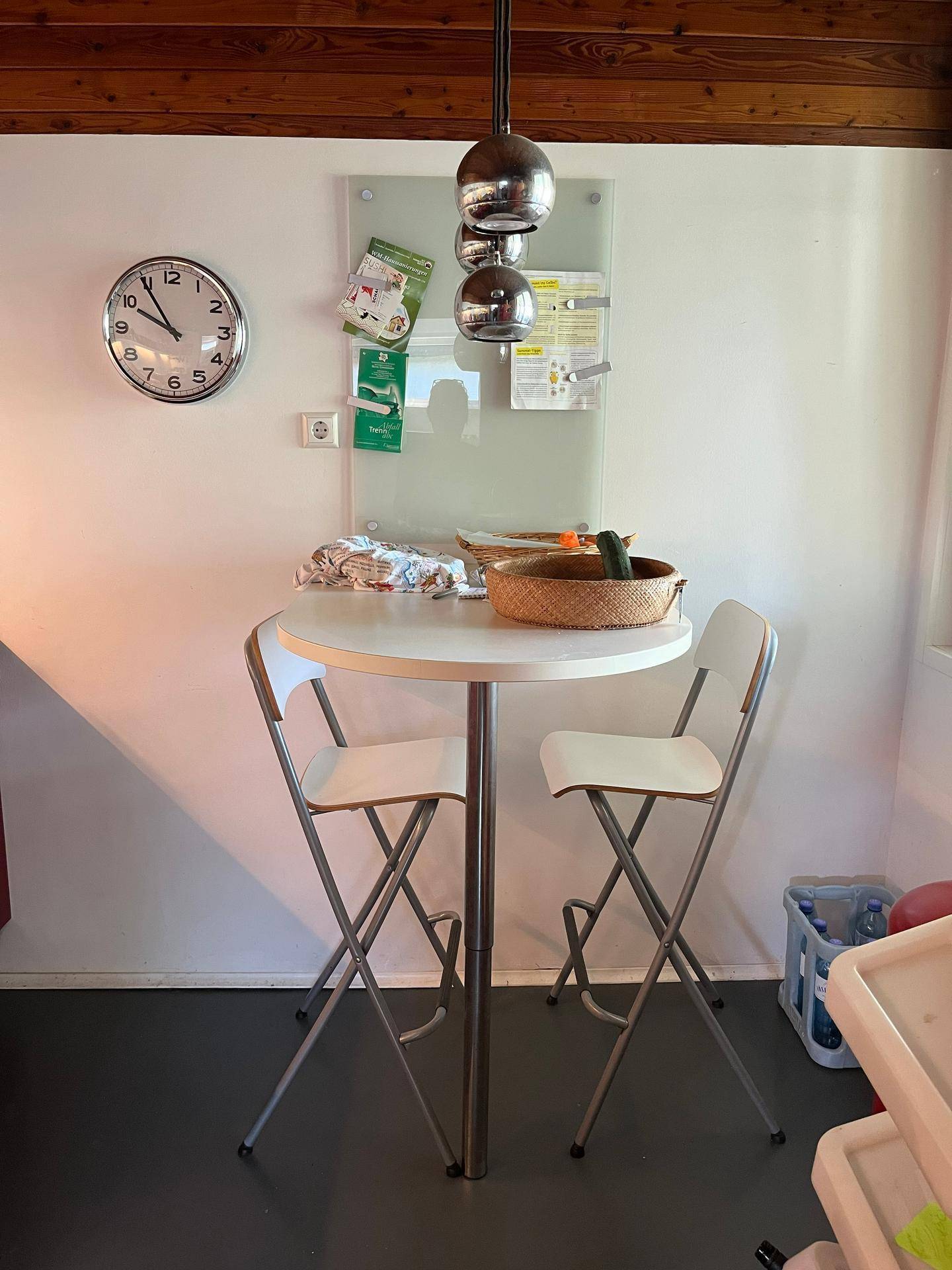 Kleiner Essbereich in der Küche mit Bartisch, Hockern und einer modernen Pendelleuchte.