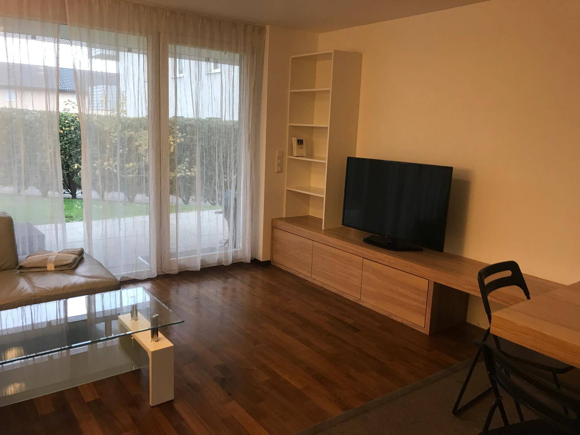 Wohnzimmer mit Sofa, Couchtisch und TV-Möbel, mit direktem Zugang zum Garten.