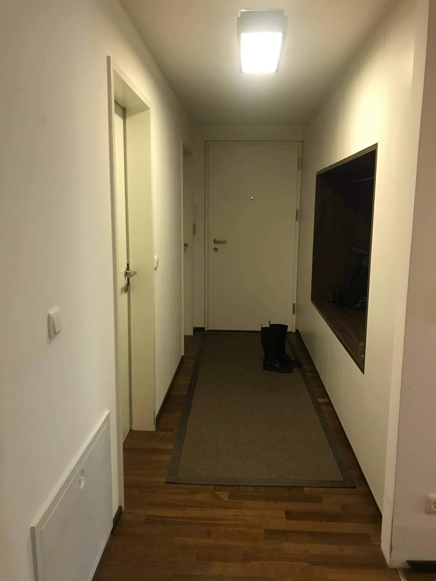 Heller Flur mit Parkettboden und einer praktischen Nische, ideal für Garderobe.