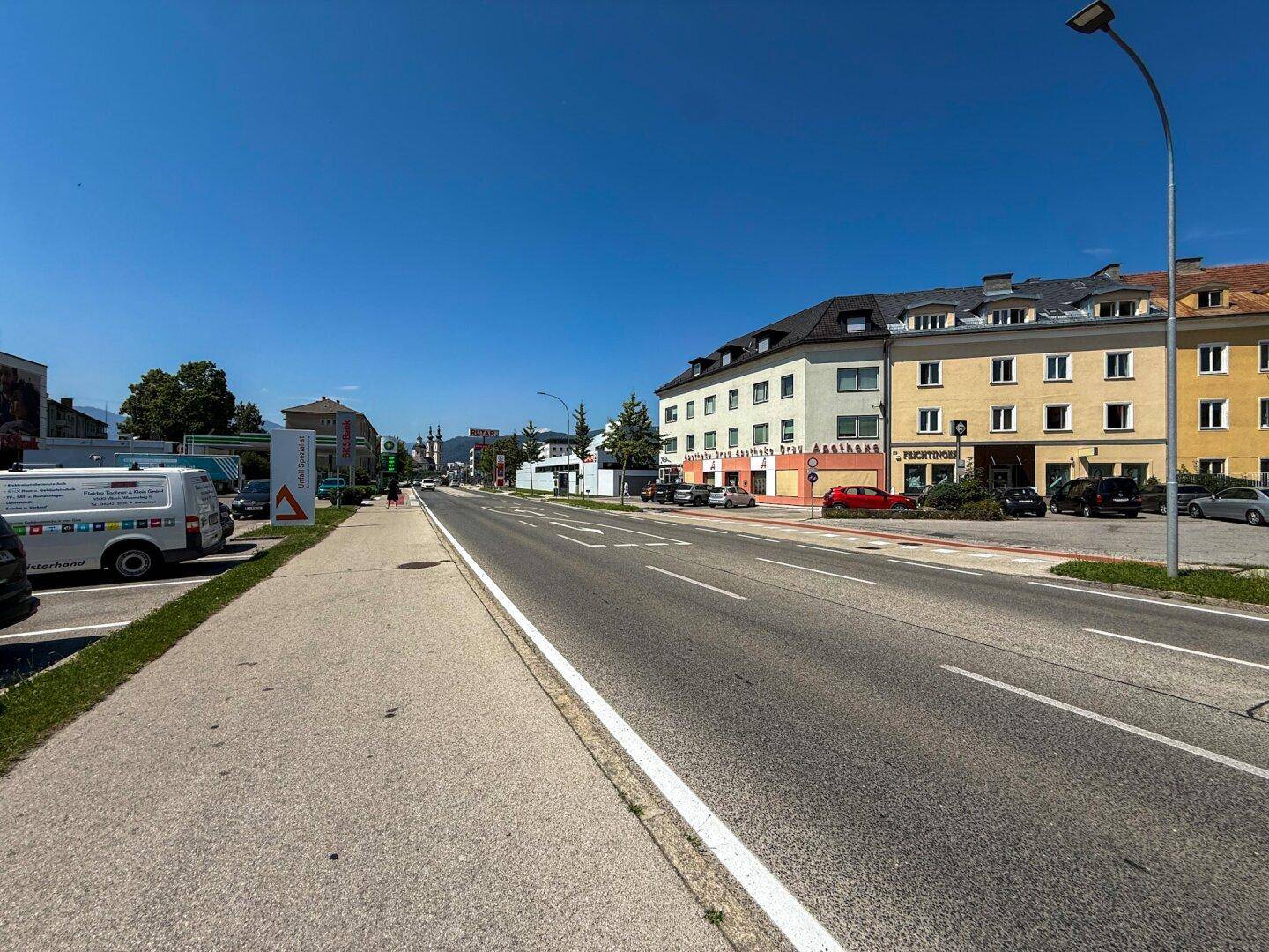 Eine weitere Perspektive der Straße, die zum Gebäude führt, mit klarem Himmel und sonnigem Wetter.