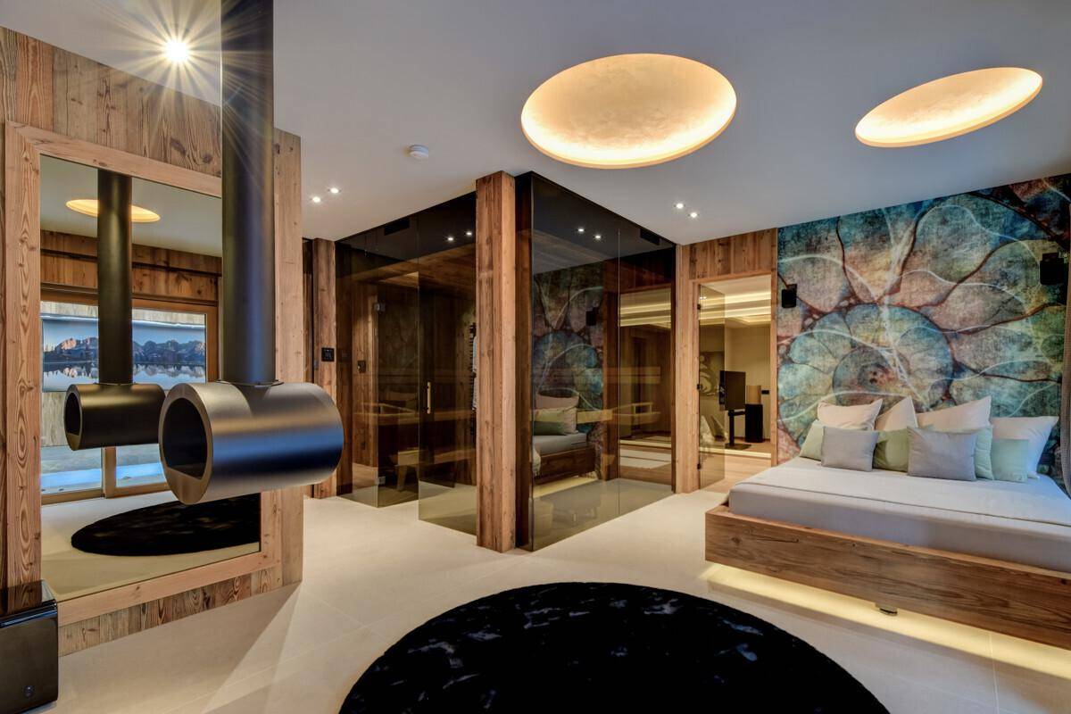 Luxuriöses Schlafzimmer mit Kamin, integrierter Sauna und Zugang zu einem privaten Außenbereich.