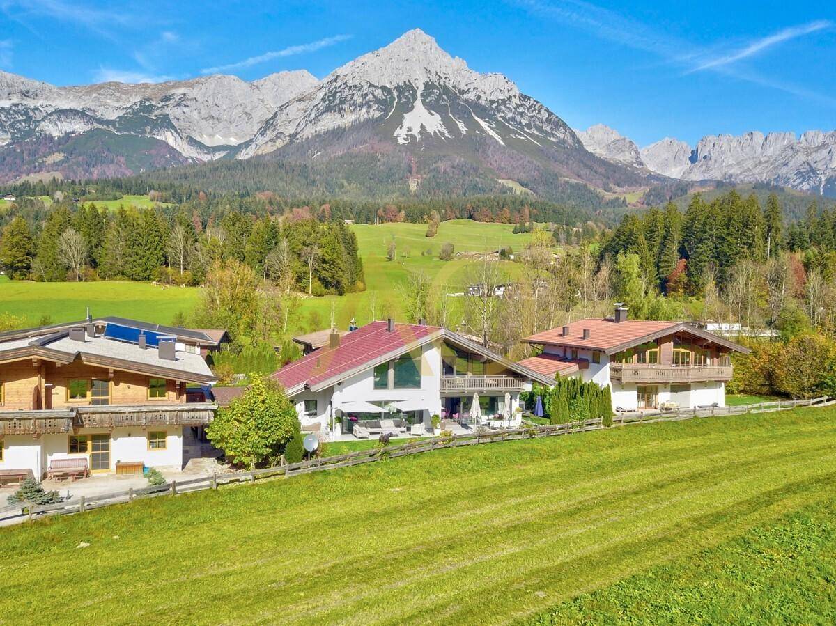 Panoramablick auf die Villa mit Terrasse, Garten und der majestätischen Bergkulisse im Hintergrund.