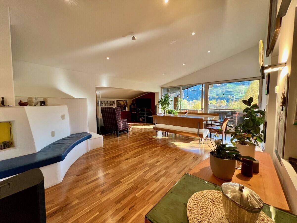 Geräumiger Wohnbereich mit Holzboden, integrierter Sitzbank und Blick auf den Essbereich.