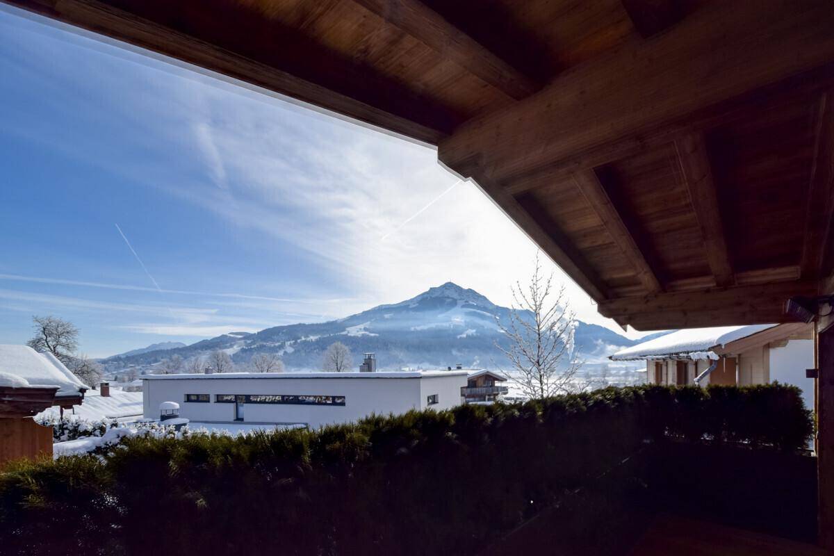 Panoramablick von einem Balkon auf die schneebedeckten Berge und die weite Landschaft.