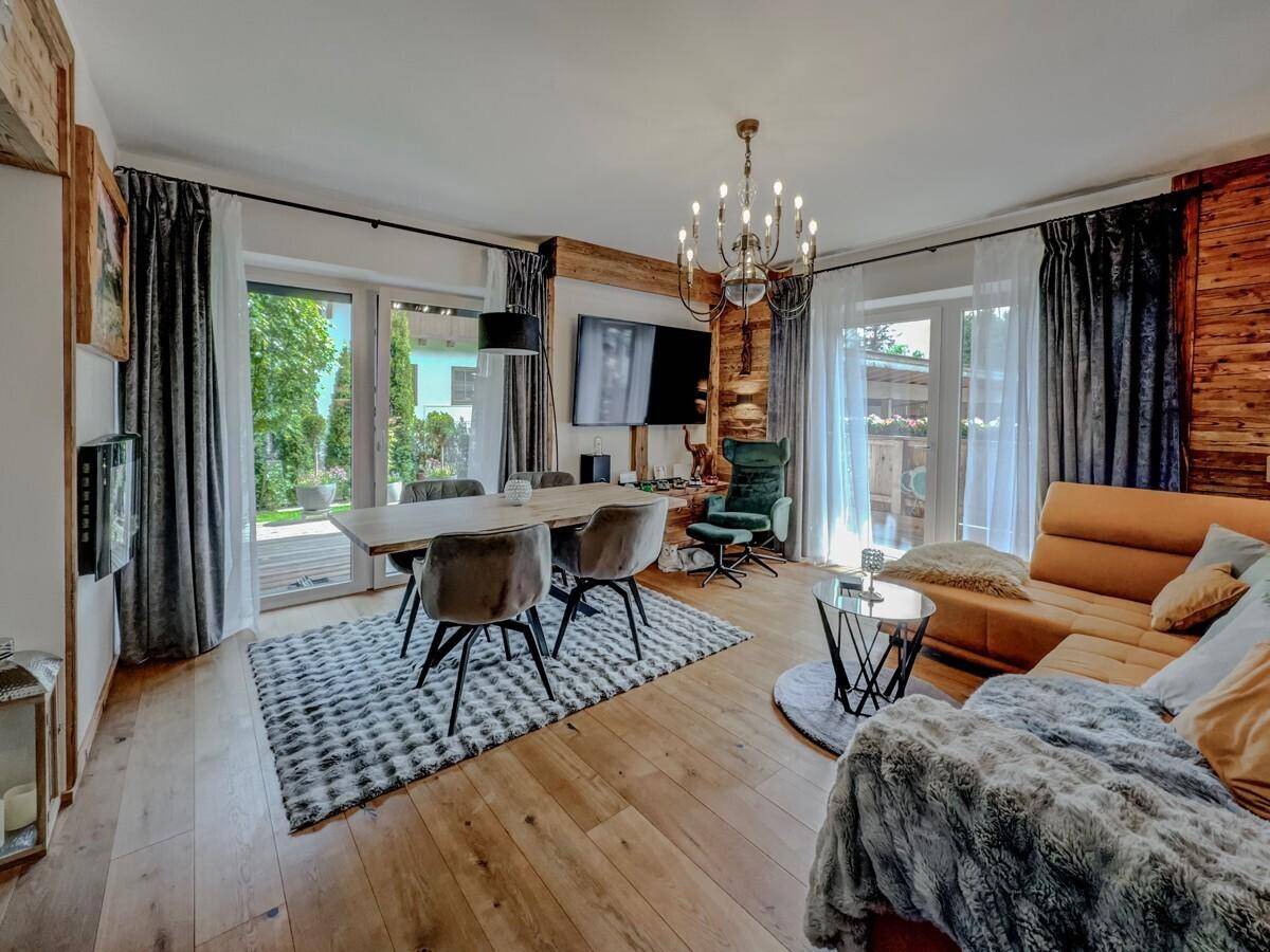Gemütlicher Wohn-Essbereich im Chalet-Stil mit Holzwänden, Esstisch und bequemer Sitzecke.