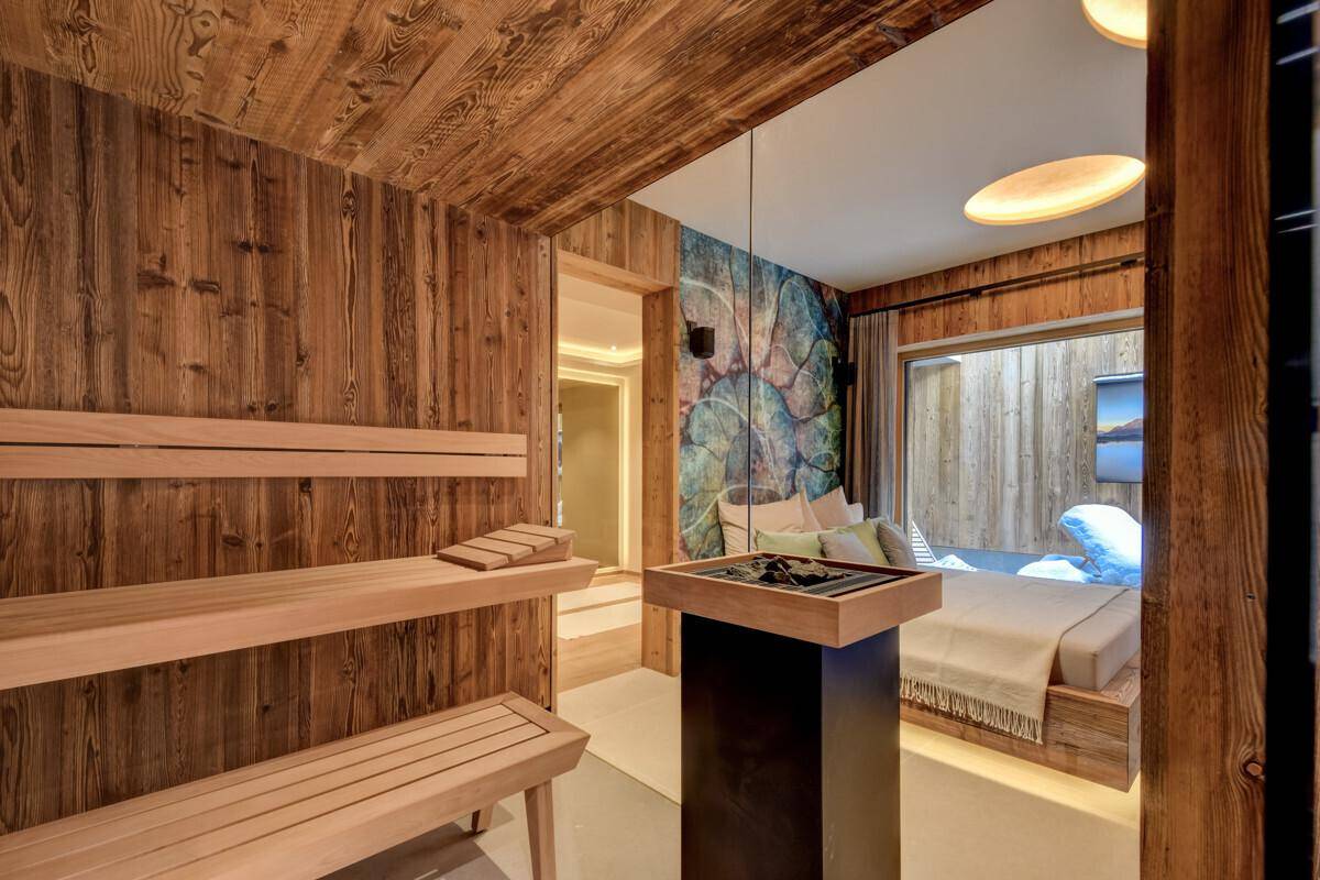 Private Sauna mit Holzbänken und Blick auf den angrenzenden Schlaf- und Wellnessbereich.