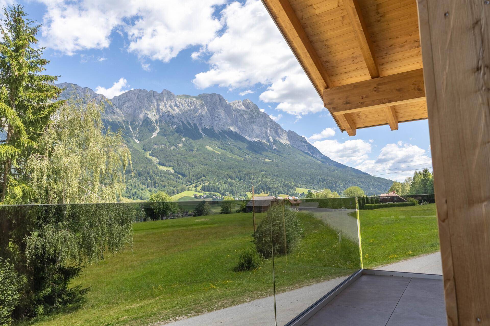 Panoramablick von der Terrasse auf die majestätischen Berge und die grüne Landschaft.