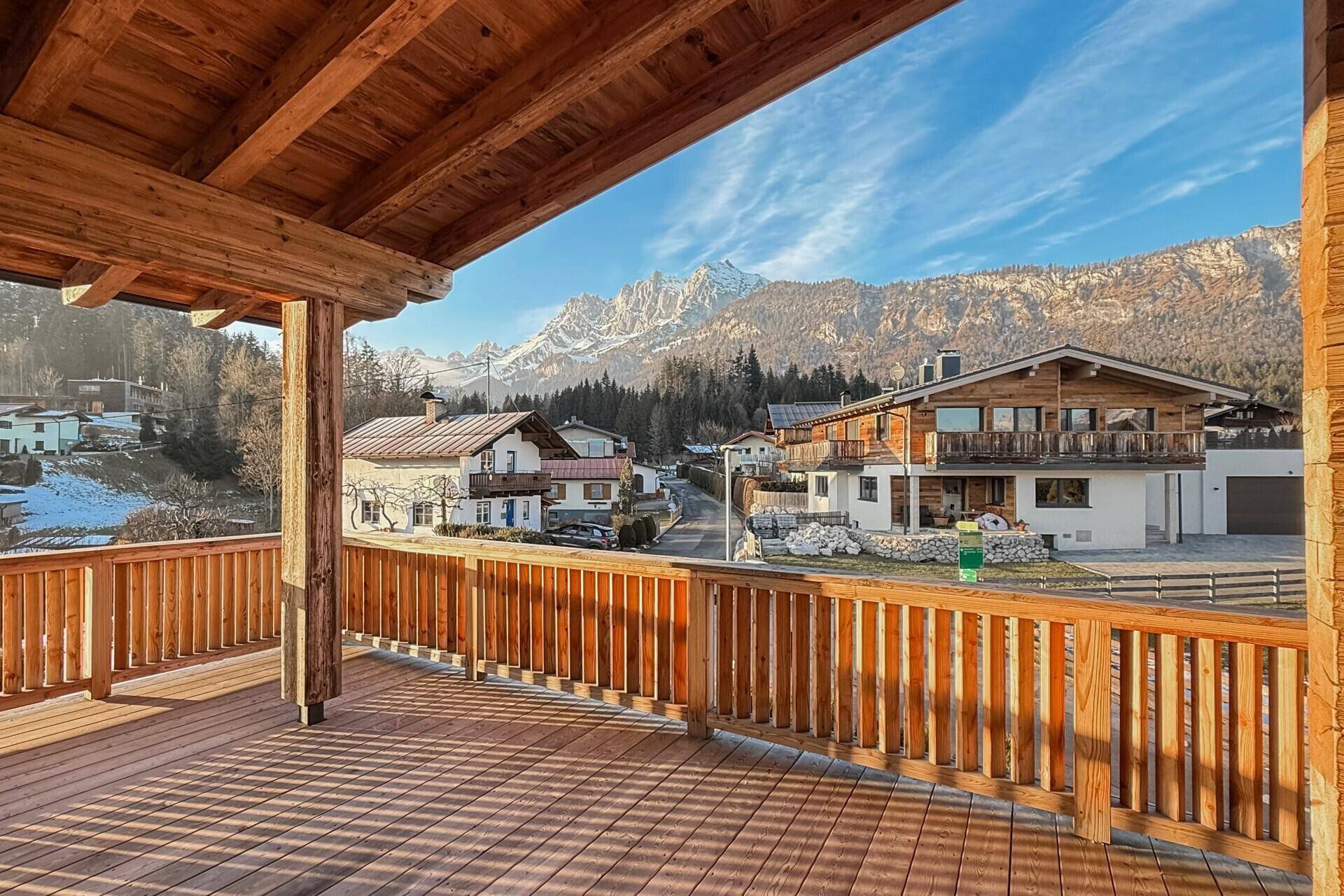 Geräumiger Holzbalkon mit Bergblick und viel Sonnenschein, ideal zum Entspannen im Freien.