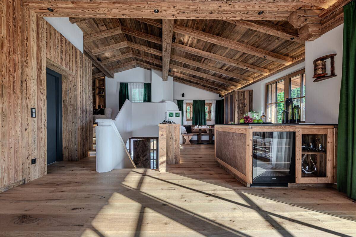 Heller Eingangsbereich mit Holzwänden, Treppe und integriertem Weinkühler.