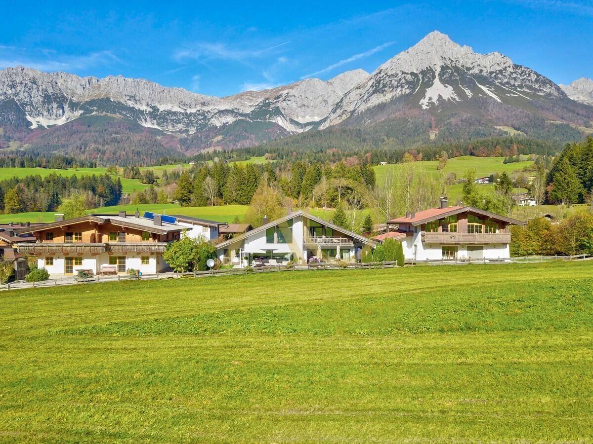 Panoramablick auf die Villa mit Terrasse, Garten und der majestätischen Bergkulisse im Hintergrund.