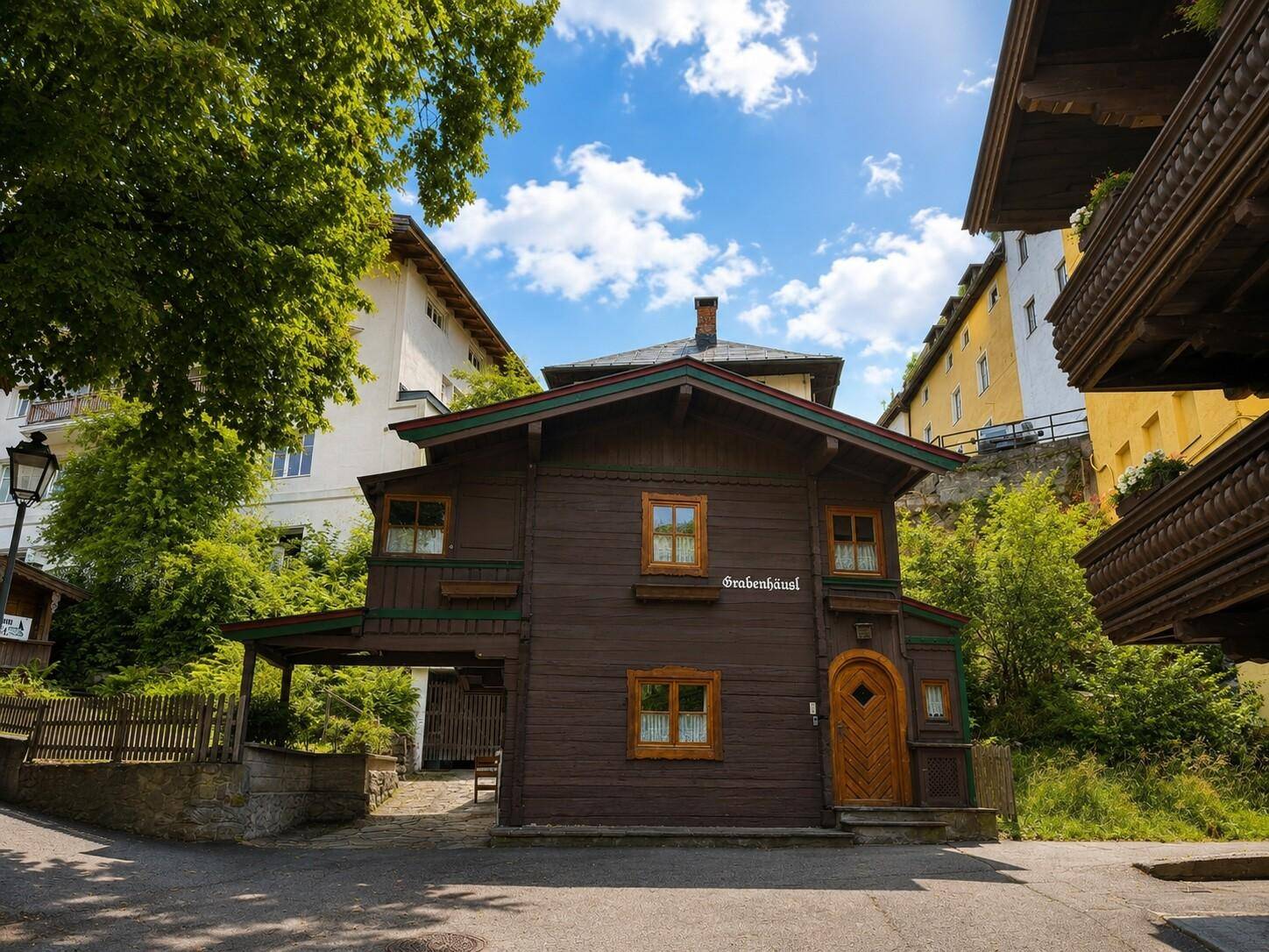 Traditionelles Holzhaus mit markanter Holzfassade und geschnitzten Details, gelegen an einer ruhigen Straße.