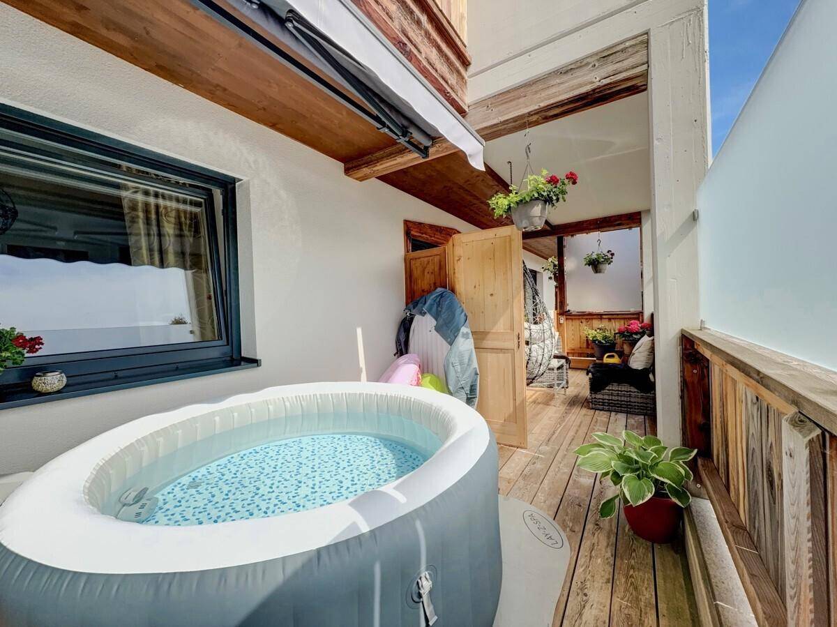 Überdachter Balkon mit aufblasbarem Whirlpool und Zugang zu weiteren Außenbereichen.