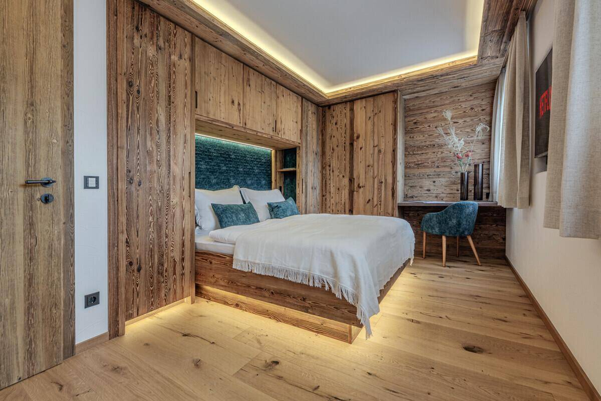 Gemütliches Schlafzimmer mit eingebauten Holzschränken, indirekter Beleuchtung und modernem Design.