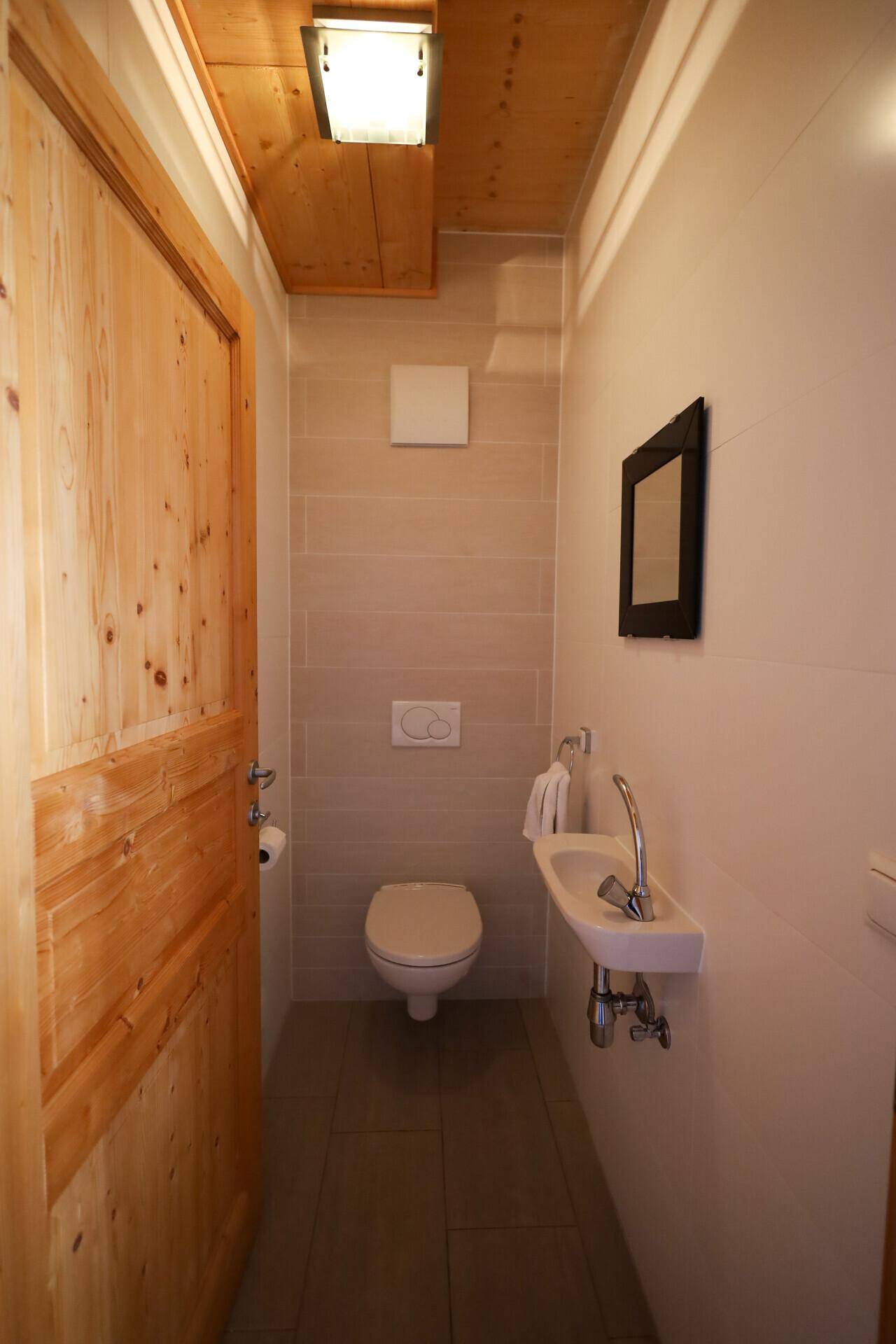 Modernes Gäste-WC mit Wand-WC und kleinem Waschbecken.