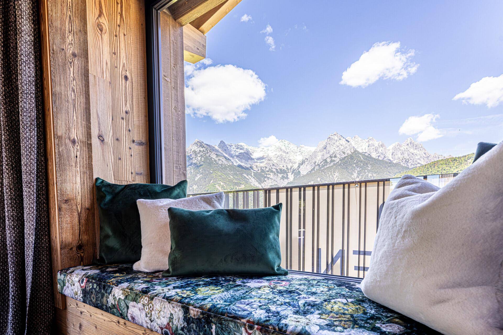Fensterbank mit Kissen bietet einen malerischen Blick auf die schneebedeckten Berge.