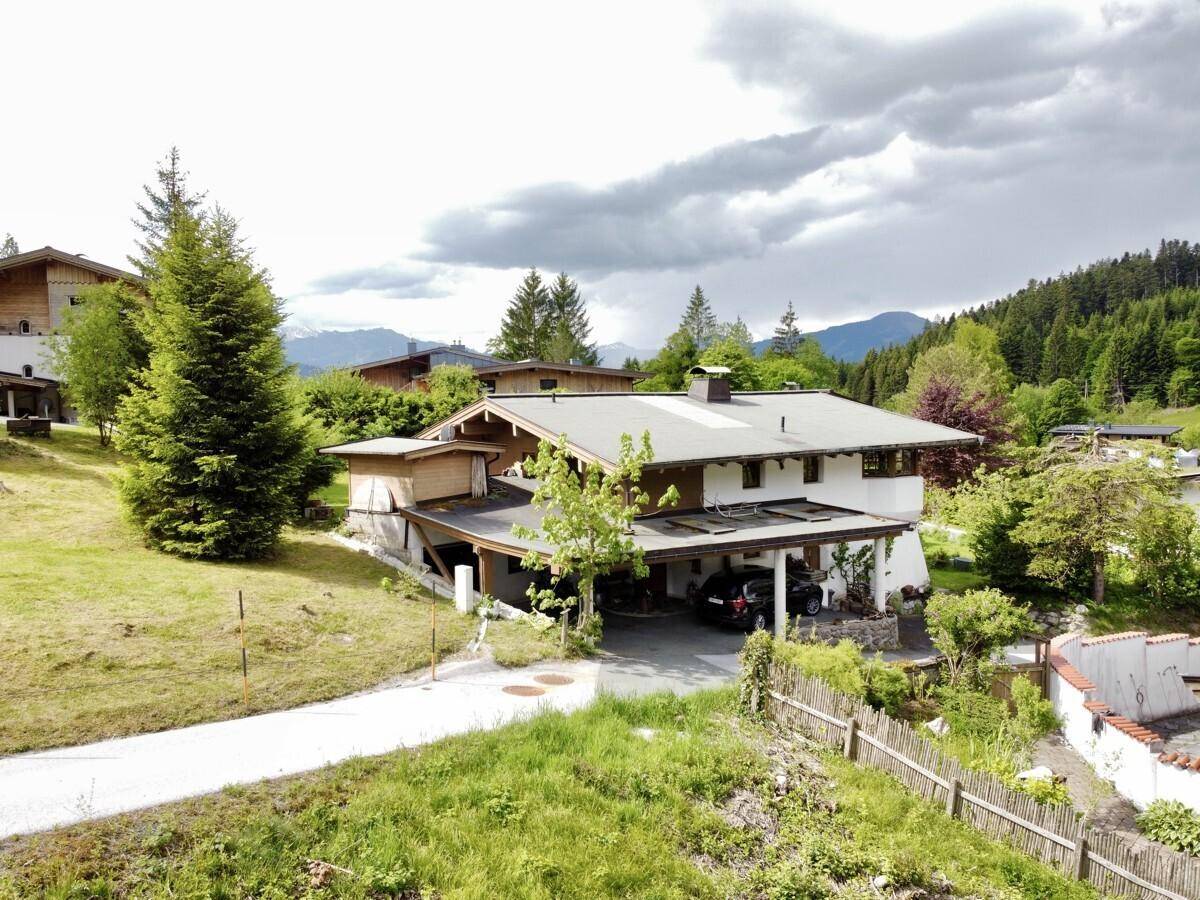 Bestehendes Wohnhaus mit Carport und grüner Umgebung in ländlicher Lage.