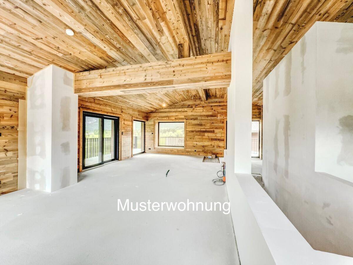 Offener Wohnraum im Neubau mit beeindruckender Holzdecke und viel Tageslicht.