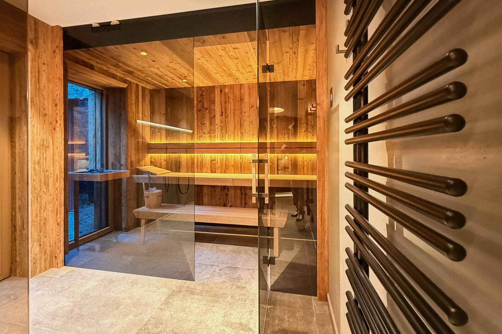 Moderne Sauna mit Holzbänken und indirekter Beleuchtung, ideal zur Entspannung und Wellness.