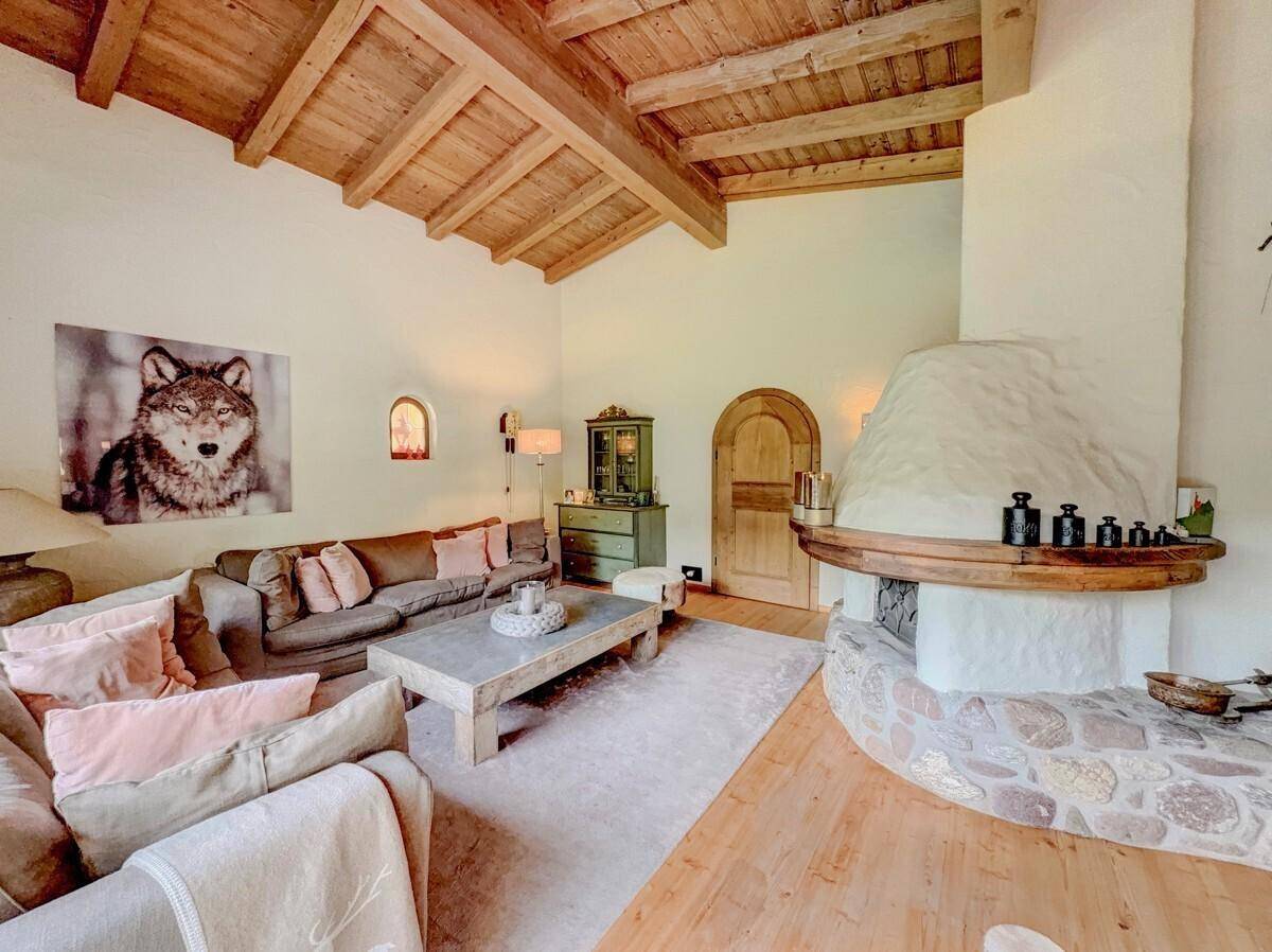 Helles Wohnzimmer mit großem Kamin, bequemen Sofas und Holzbalkendecke.