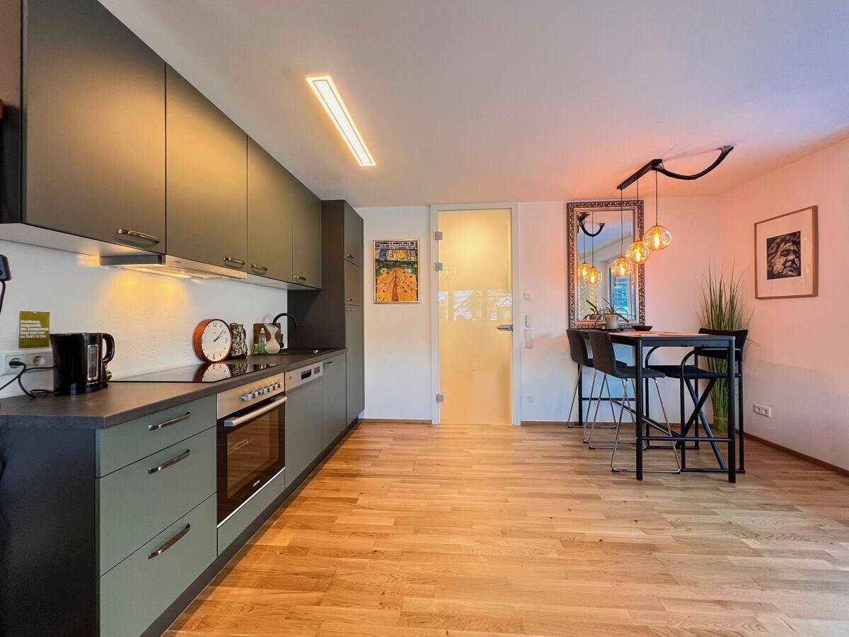 Moderne Küchenzeile mit Essbereich und Bartisch, ideal für gesellige Runden.