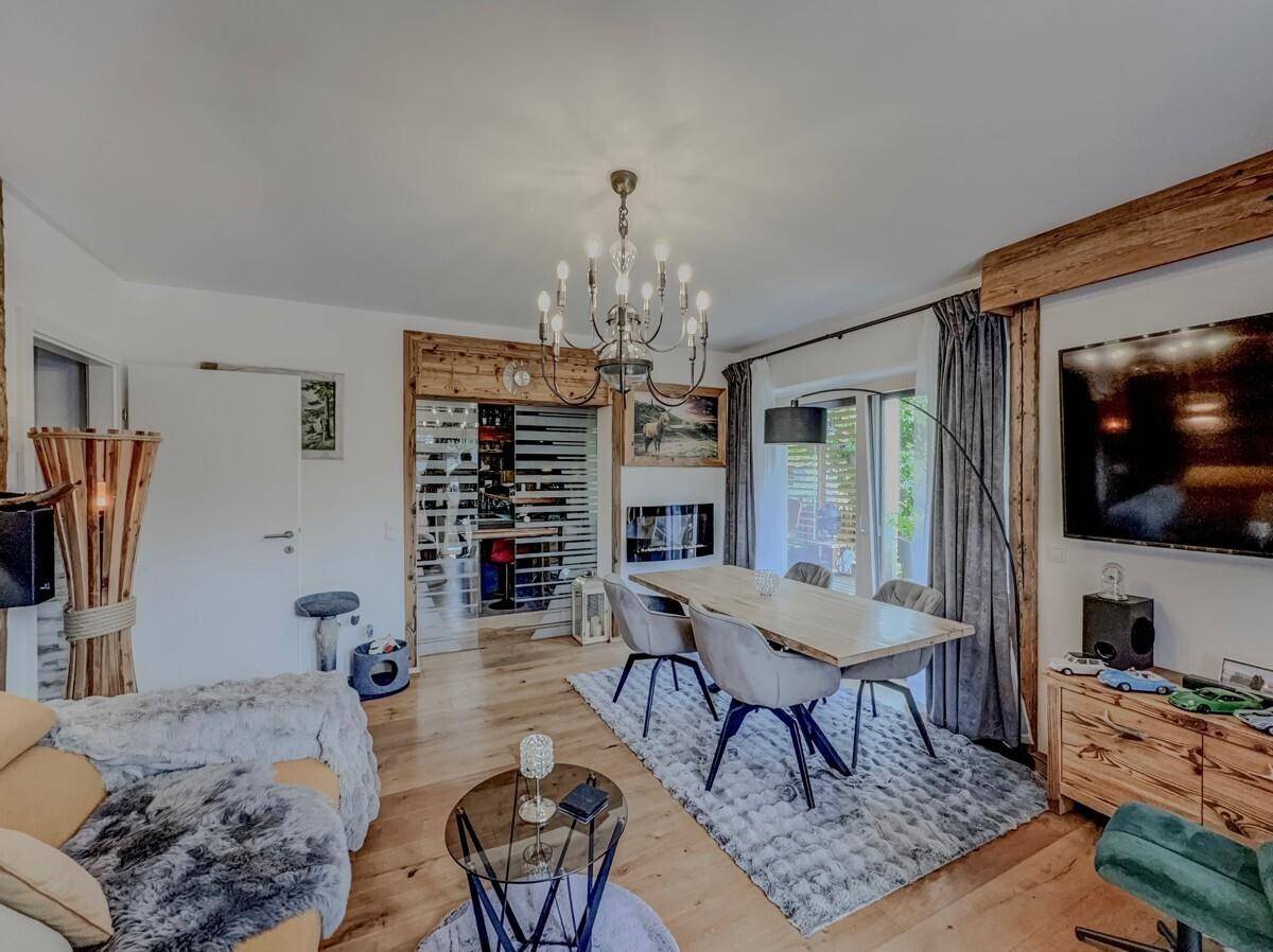 Geräumiger Wohn-Essbereich im Chalet-Stil mit Holzboden, gemütlicher Sitzecke und dekorativem Kamin.