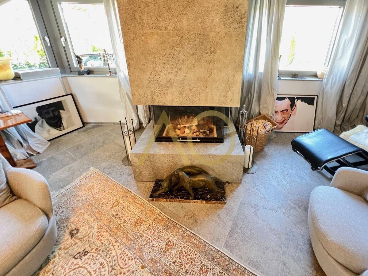 Gemütliches Wohnzimmer mit Kamin, Teppich und stilvoller Einrichtung.