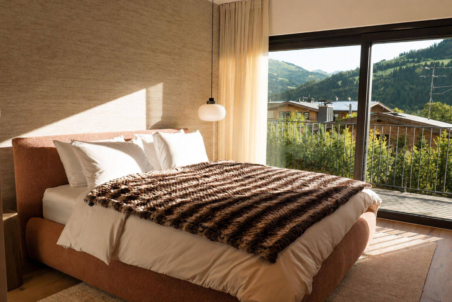 Gemütliches Schlafzimmer mit weichem Teppich, großem Fenster und sonnigem Ausblick auf die Umgebung.