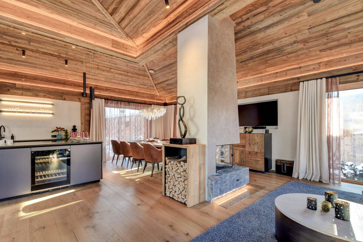 Eleganter Wohn- und Essbereich mit integrierter Bar, Kamin und hochwertigen Holzoberflächen.