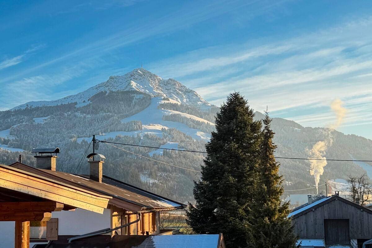 Malerischer Blick auf die schneebedeckten Berge und Dächer der umliegenden Häuser.
